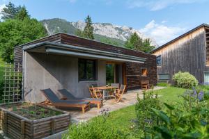 a house with a patio with chairs and a table at Gartenlodge Auszeit in Nötsch