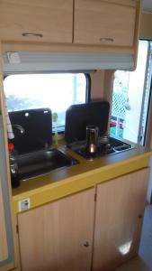 a kitchen with a sink and a stove in an rv at Chalet en oasis privado in La Vegueta