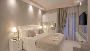 um quarto com uma cama branca e toalhas em Amaryllis Luxury Rooms em Platamonas