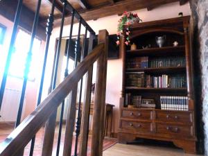 ein hölzernes Bücherregal mit Büchern und einer Treppe in der Unterkunft Casa rural El Tejo in Bermiego