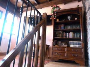 a wooden book shelf with books and a staircase at Casa rural El Tejo in Bermiego