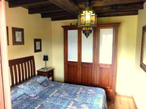 a bedroom with a bed and a chandelier at Casa rural El Tejo in Bermiego