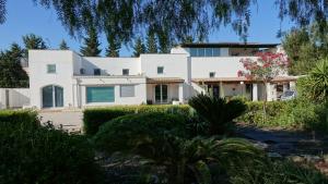 a large white house with trees in front of it at Masseria Donna Laura di Adriana Giangrande in Arnesano