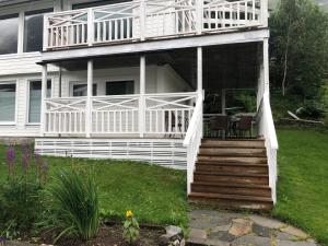 a large white house with a porch and stairs at Jolster sauna apartments in Skei