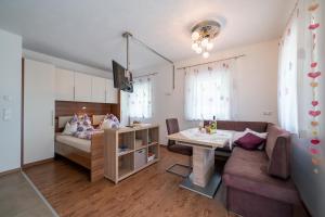 - un salon avec un canapé et un lit dans l'établissement Appartements Salentinig, à Flattach