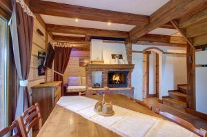 a dining room with a table and a fireplace at Prie Klykio in Utena
