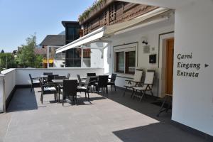 een restaurant met tafels en stoelen op een patio bij Garni Birkenau in San Martino