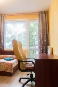 a bedroom with a desk and a chair and a window at Apartment Eve in Varna City