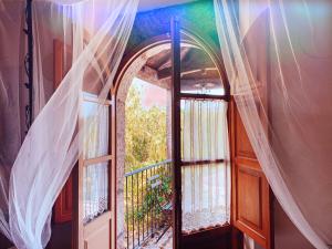 an open door to a balcony with curtains at Finca Galea in Carballido