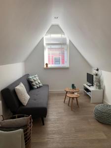 a living room with a couch and a window at Koningshof in Alkmaar