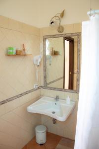 een badkamer met een wastafel en een spiegel bij Agriturismo Terra Di Elea in Ascea