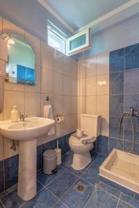 a bathroom with a sink toilet and a mirror at Katerina Rooms & Apartments in Skala Potamias