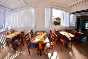 a dining room with wooden tables and chairs at Pousada Fernandes in Arraial do Cabo
