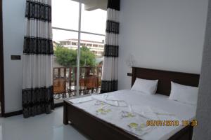 1 dormitorio con 1 cama y balcón en The Amora, en Arugam Bay