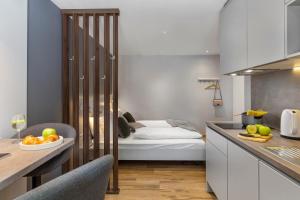 a kitchen with a bed and a table with a bowl of fruit at InCenter Apartments Rijeka in Rijeka
