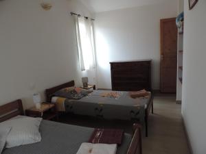 1 dormitorio con 2 camas, vestidor y ventana en Les Cigales d'Estoublon, en Estoublon