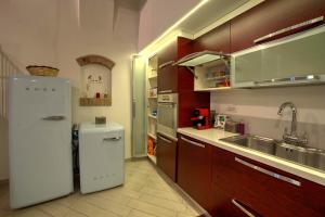 La cuisine est équipée d'un réfrigérateur blanc et d'un évier. dans l'établissement Cozy Apartment in the heart of Siena, à Sienne