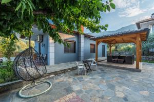 a patio of a house with a swing at Katerina Rooms & Apartments in Skala Potamias