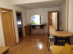 a living room with a table and a kitchen at Apartamento CUATTRO vut 47-169 wifi in Valladolid