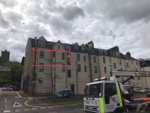 a building with a red ribbon on the side of it at Prime location rooms in high street in Fort William