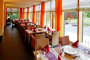 a restaurant with wooden tables and chairs with red napkins at Nashira Kurpark Hotel -100 prozent barrierefrei- in Bad Herrenalb