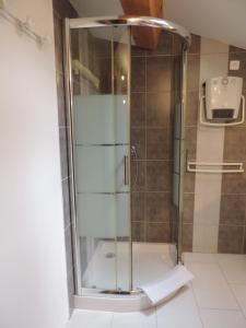a shower with a glass door in a bathroom at Les Cigales d'Estoublon in Estoublon