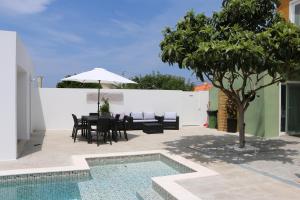 a patio with a table and chairs and a tree at Casinha Verde in Nadadouro