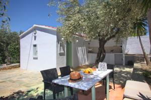 ein Tisch mit einem Kuchen neben einem Baum in der Unterkunft Liogerma Cottage in Panormos Skopelos