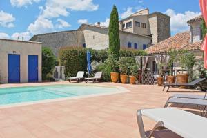 una piscina con sedie e una casa di Le Mas de Crieulon a Saint-Jean-de-Crieulon