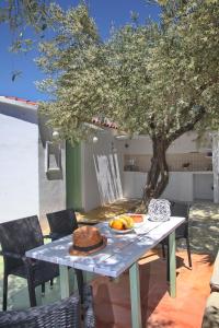 a table with a cake on it under a tree at Liogerma Cottage in Panormos Skopelos