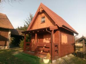 une cabane en bois avec un toit en gambrel dans l'établissement Nowe Domki Pod Lipami, à Junoszyno