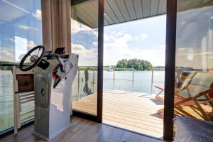 a house with a deck with a view of the water at Apartament Na Wodzie in Ruciane-Nida