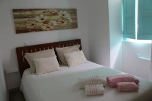 a bedroom with a bed with two pillows on it at Casinha Verde in Nadadouro +16 photos