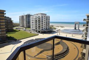a balcony with a view of the beach and buildings at plaza in De Panne