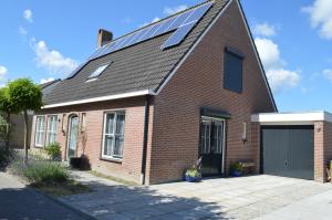 een rood bakstenen huis met zonnepanelen op het dak bij Veugelvrie in Kamperland