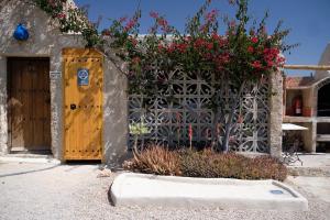 a building with a wooden door and flowers at Cortijo La Joya de Cabo de Gata in Agua Amarga