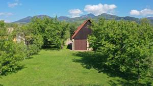a barn in the middle of a field with trees at River Side Holiday Home near Besenova in Ivachnová