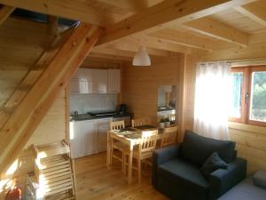 ein Wohnzimmer und eine Küche in einem Blockhaus in der Unterkunft Nowe Domki Pod Lipami in Junoszyno