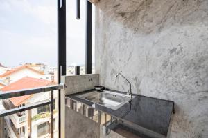 un lavabo en una pared de piedra con una ventana en My Style Resort Hotel -SHA Plus, en Patong Beach