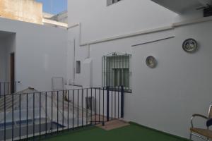 a white building with a staircase and a gate at De Cadiz Cadi Hostel in Cádiz
