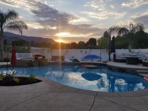 a swimming pool with a sunset in the background at Sweet Wildomar Retreat in Wildomar