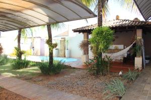 um pátio com uma rede e uma casa em Casa Magnífica em Olímpia