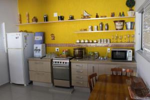 een keuken met een fornuis, een koelkast en een tafel bij Casa Magnífica in Olímpia