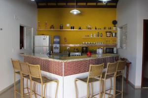 een keuken met een bar met stoelen eromheen bij Casa Magnífica in Olímpia +5 foto's