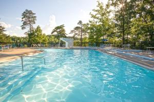 a swimming pool with blue water and trees at Pennyrile Forest State Resort Park in Hawkins