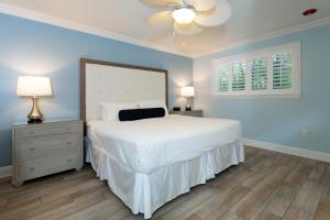 ein Schlafzimmer mit einem großen weißen Bett mit blauen Wänden in der Unterkunft Crane's Beach House Boutique Hotel & Luxury Villas in Delray Beach