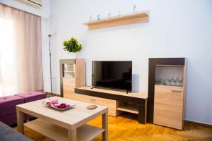 een woonkamer met een tv en een tafel bij Acropolis,Historic center Apartment-update in Athene