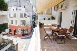 an apartment balcony with a wooden table and chairs at Acropolis,Historic center Apartment-update in Athens