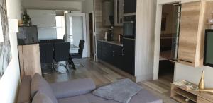 ein Wohnzimmer mit Couch und Küche in der Unterkunft Hahnenklee Ferienpark 7-611 in Goslar