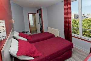 a bedroom with two beds with red sheets and a window at Hipotel Paris Belgrand Mairie du 20ème in Paris